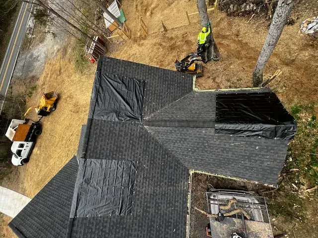 Overhead view of a tarped roof with the Greenbrier Tree Experts crew clearing storm-felled limbs