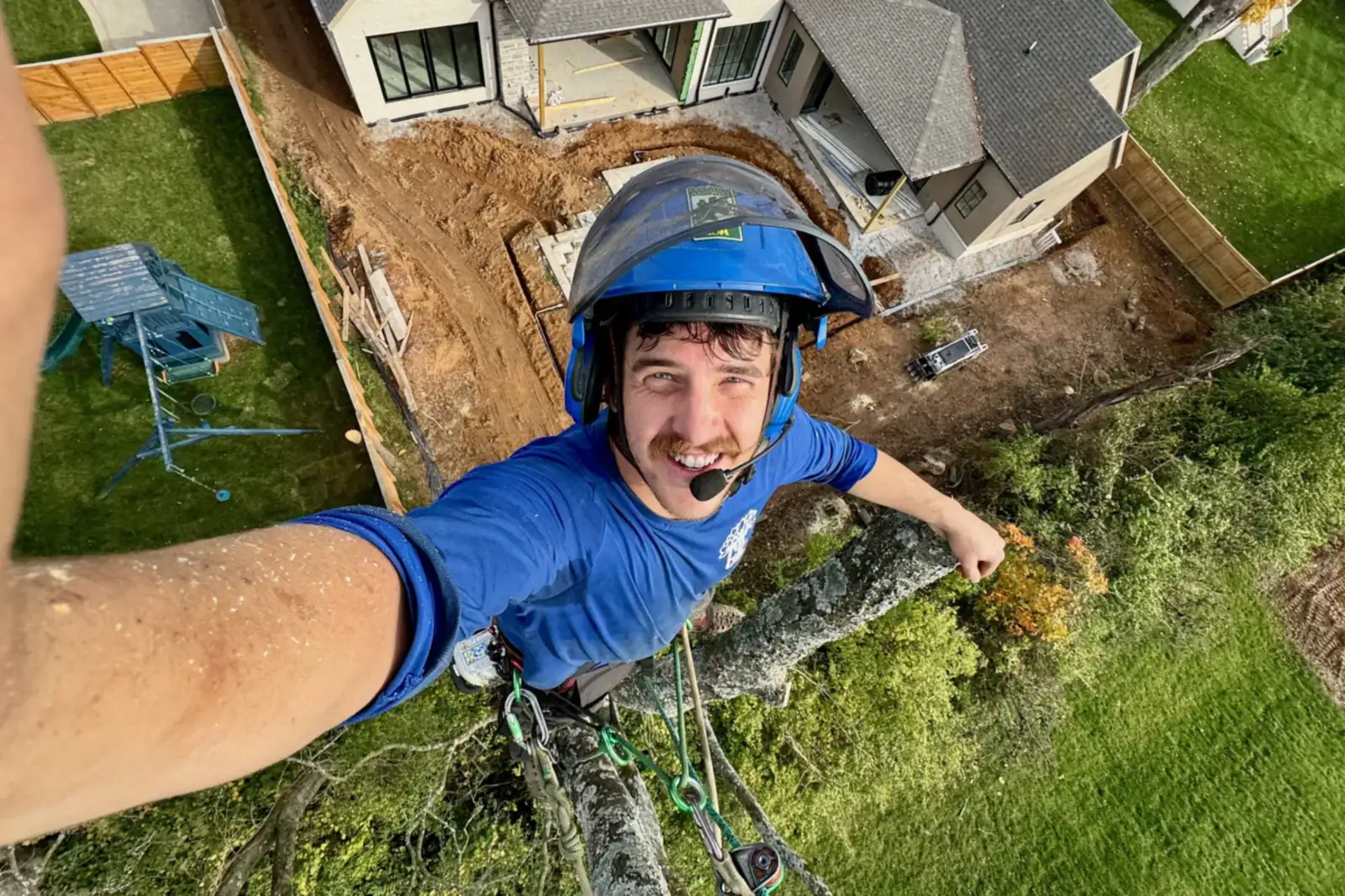 Greenbrier Tree Experts climber roped in high above a backyard tree removal